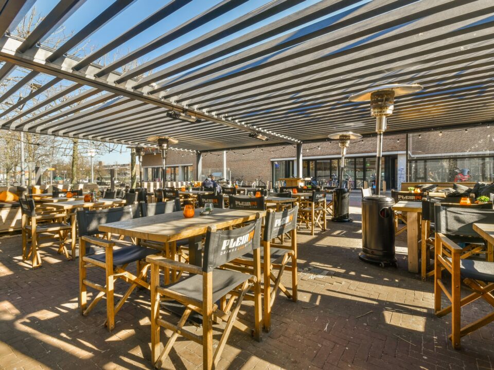 Terraza de restaurante con mesas bajo toldo